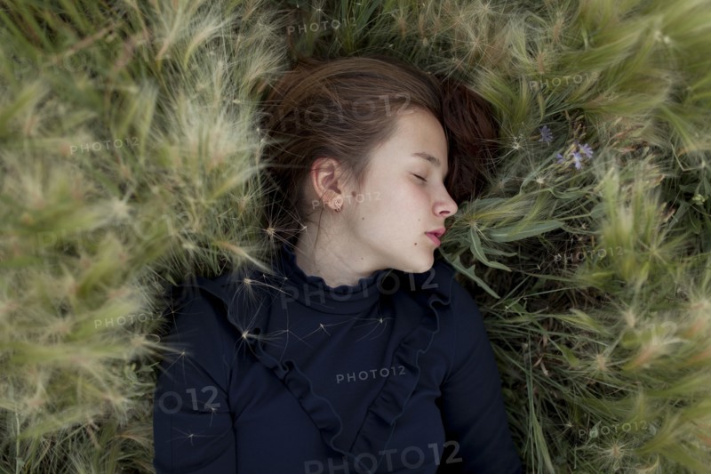 Caucasian girl laying in field