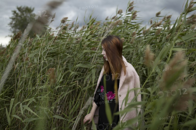 Asian woman standing in field of tall grass
