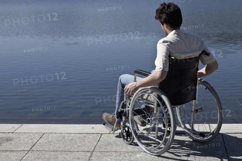Caucasian man in wheelchair sitting on dock