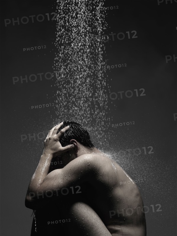 Caucasian man sitting in shower