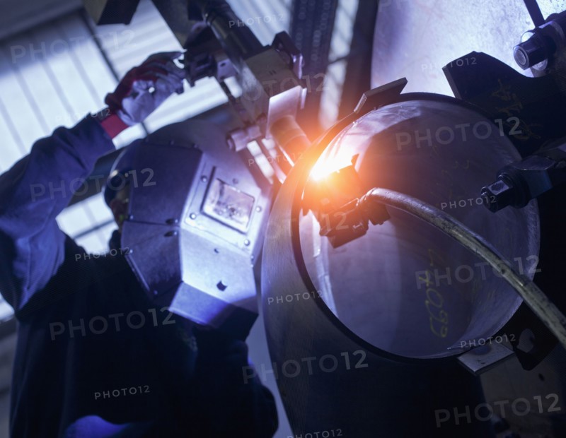 Caucasian worker working on steel pipe in factory