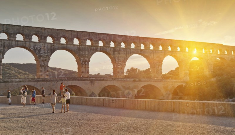 People sightseeing near aqueduct