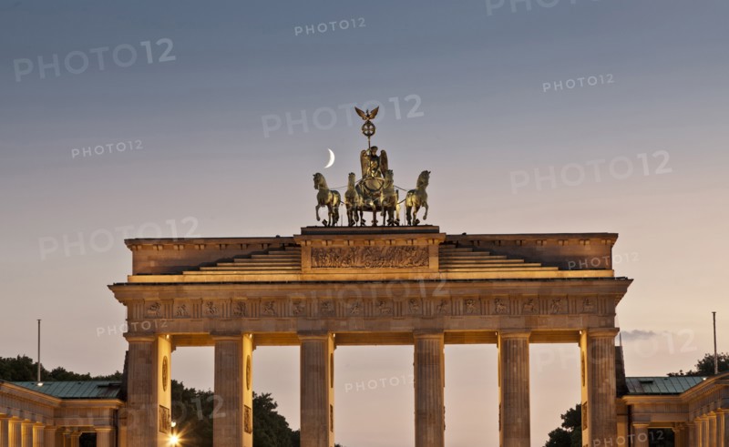 Columned building and statue lit up at night