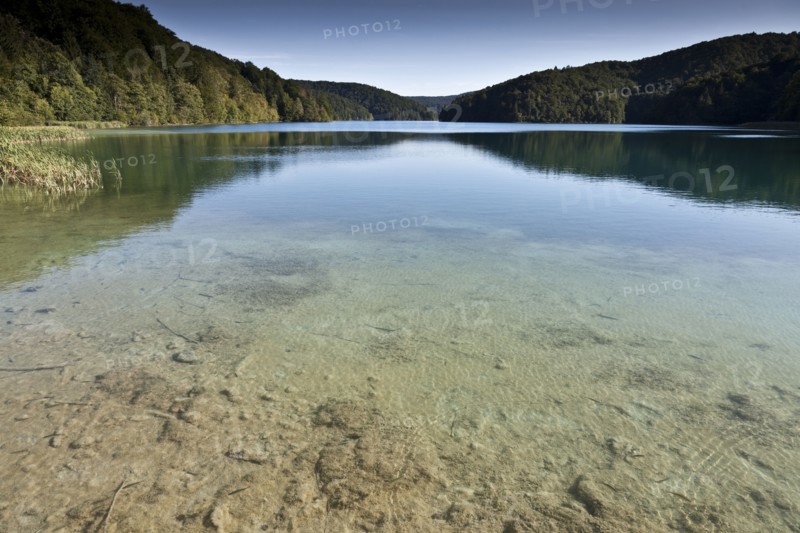 Hills and sky reflected in still lake
