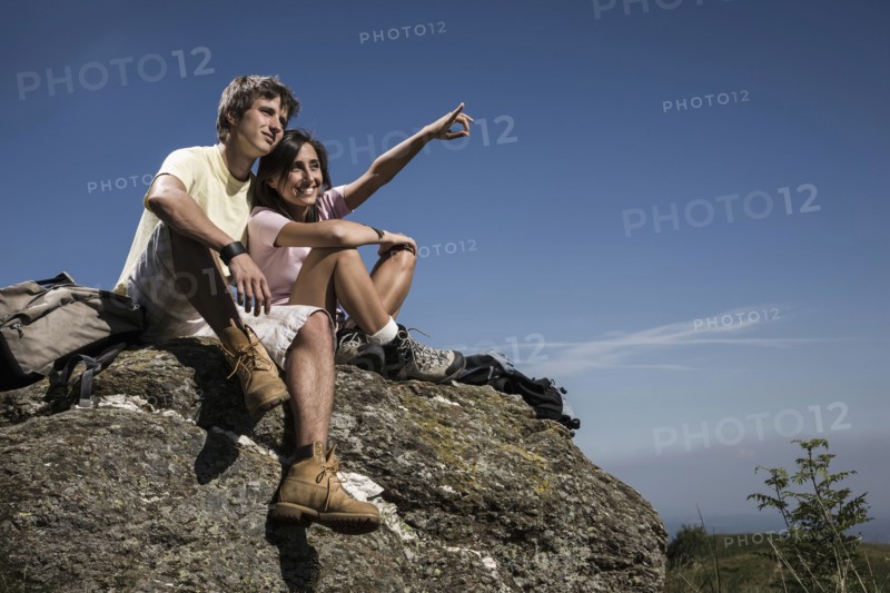 Smiling couple sitting on rock