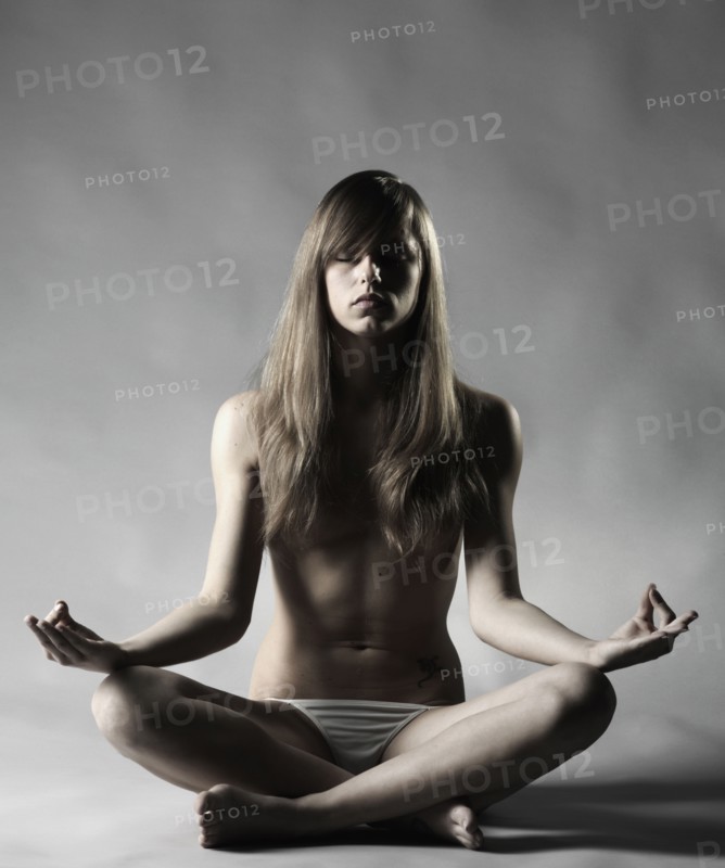 Topless Caucasian woman meditating