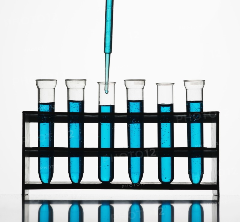 Pipette dripping blue liquid into test tubes
