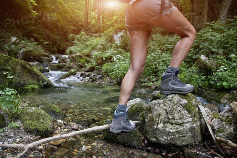 Legs of Caucasian woman hiking over river