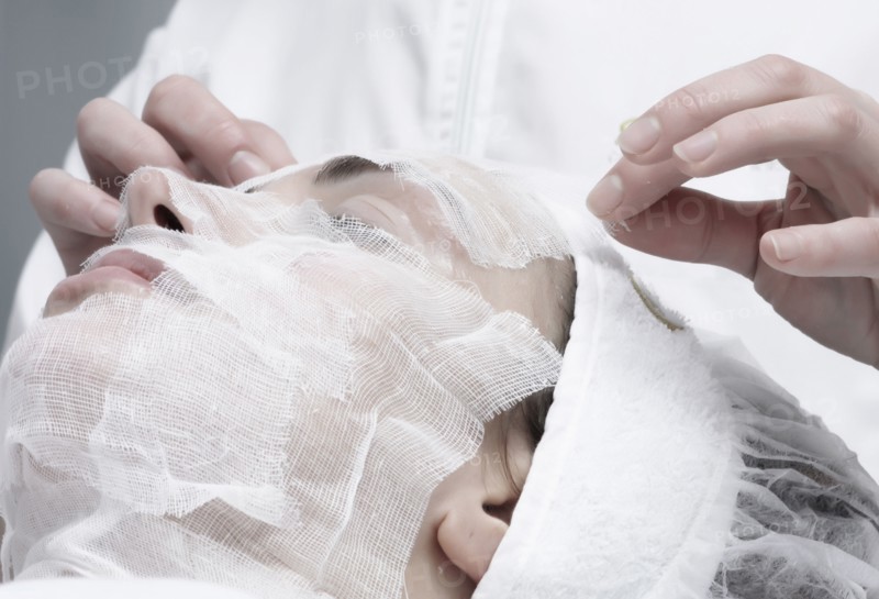 Caucasian woman receiving facial beauty treatment