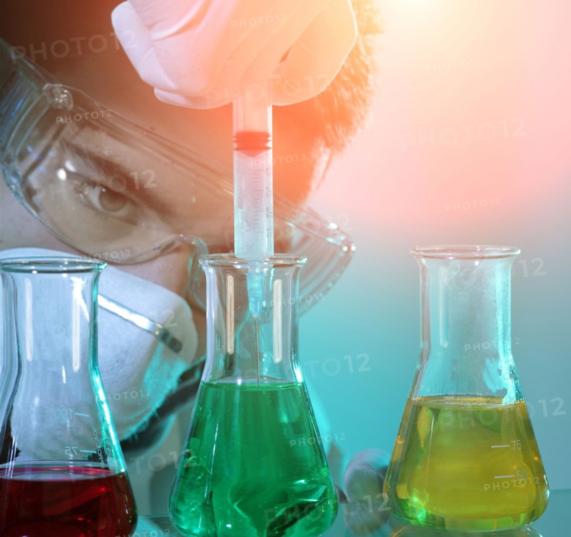 Caucasian scientist experimenting with multicolor liquids
