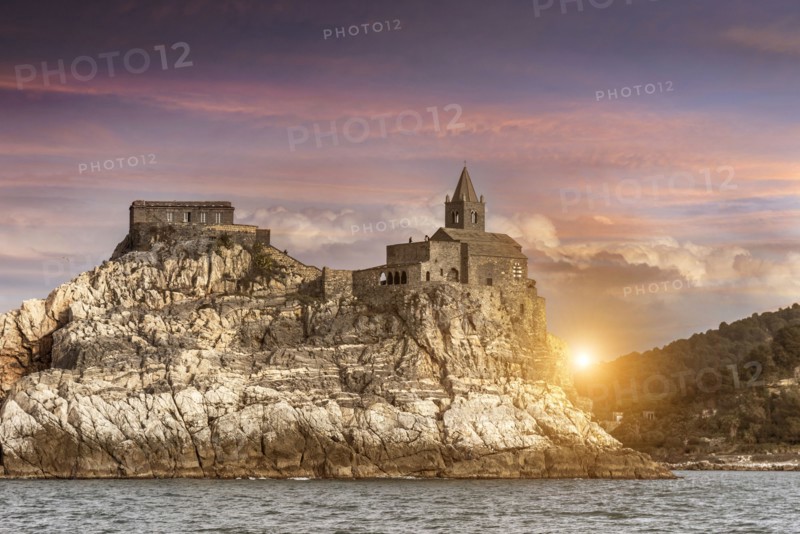 Castle on rock near river at sunset