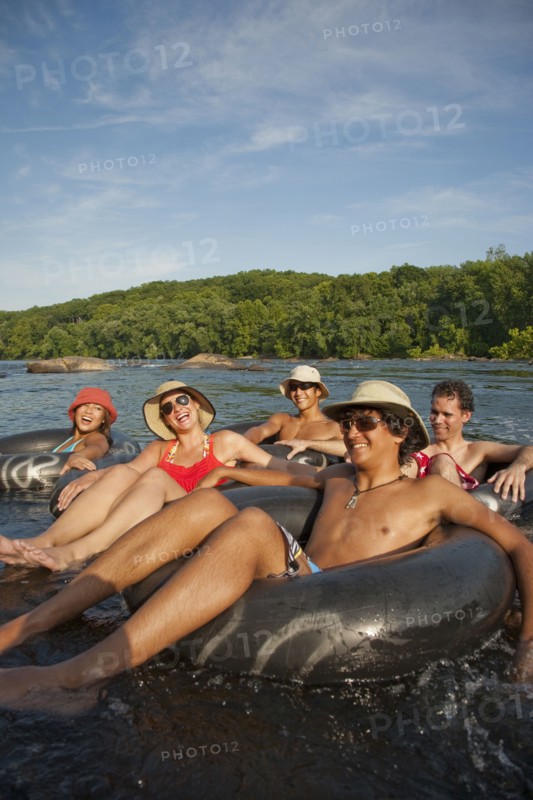 Friends floating on river in inner tubes