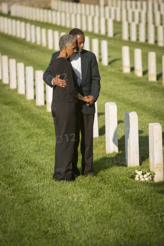 Black couple hugging in military cemetery