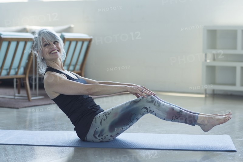 Woman doing yoga balancing on exercise mat