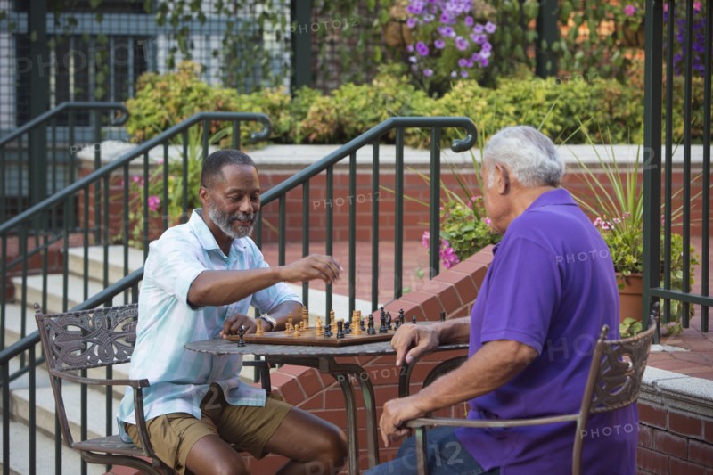 Friends playing chess in garden