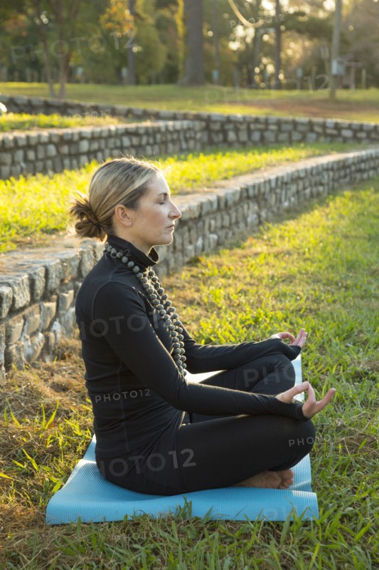 Caucasian woman meditating in park