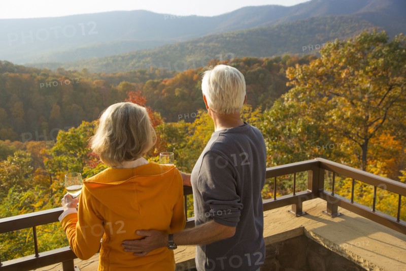 Older Caucasian couple enjoying wine and scenic view