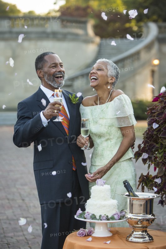 Flower petals falling on Black newlyweds