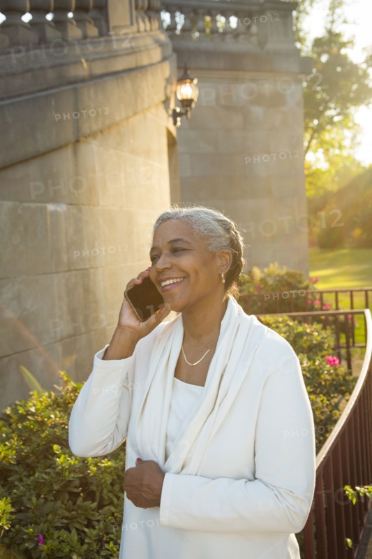Black woman talking on cell phone near stone staircase
