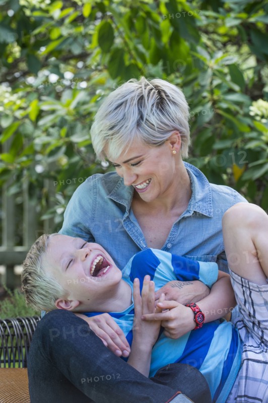 Caucasian woman tickling son outdoors