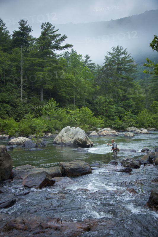 Caucasian man fishing in river