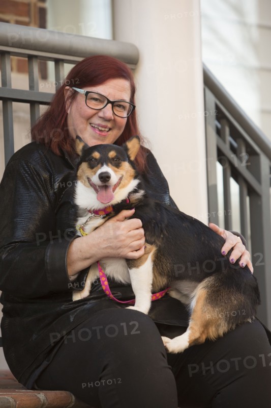Portrait of Caucasian woman sitting on stoop holding dog