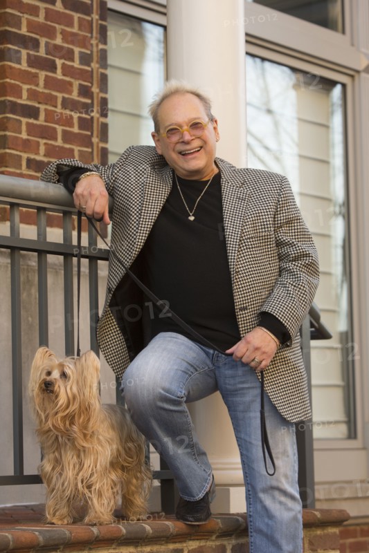 Portrait of Caucasian man leaning on stoop posing with dog