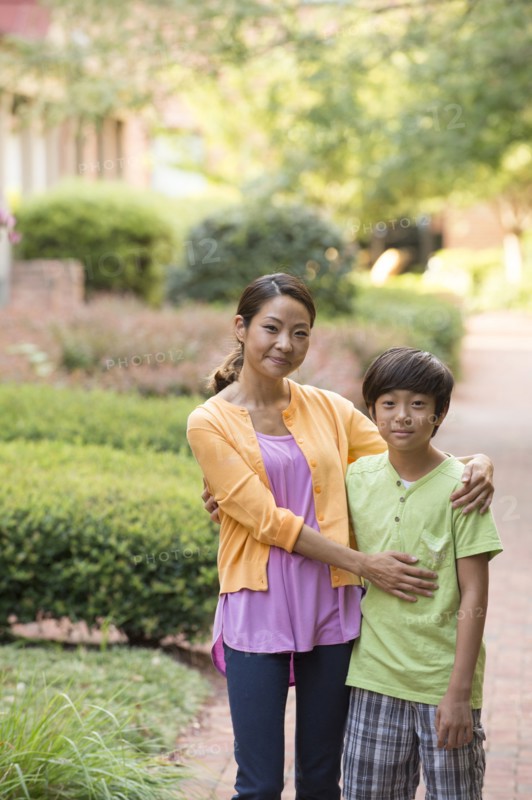 Portrait of Asian mother and son standing on sidewalk