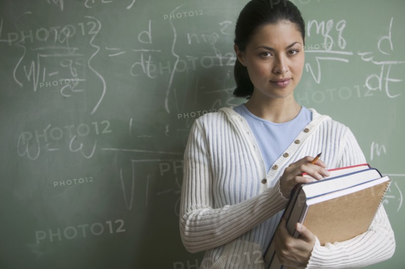 Portrait of female student holding books
