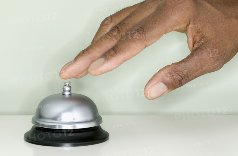 Close up of hand ringing service bell