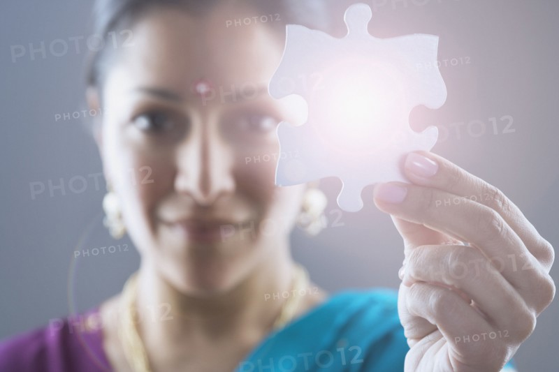 Woman in traditional Indian dress holding a puzzle piece