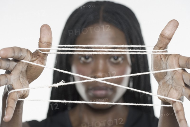 Young woman holding a cat's cradle out to the camera