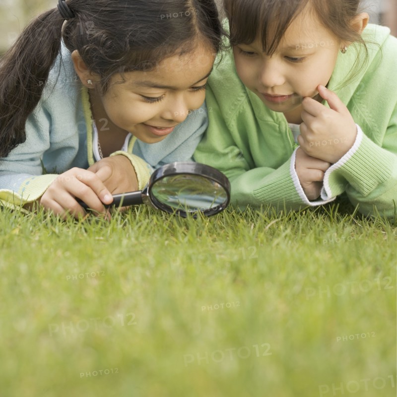 Two girls using a magnifying glass