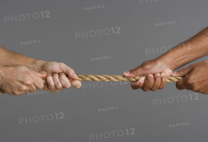 Close up of tug-o-war with four hands