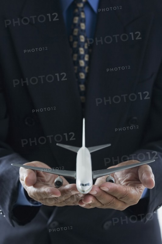 Close up of businessman's hands holding toy airplane