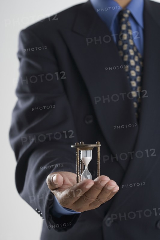 Close up of businessman's hands holding hour glass