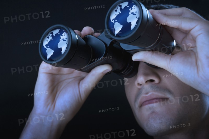 Close up of man looking at world through binoculars