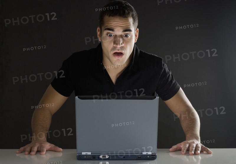 Man surprised while looking at laptop