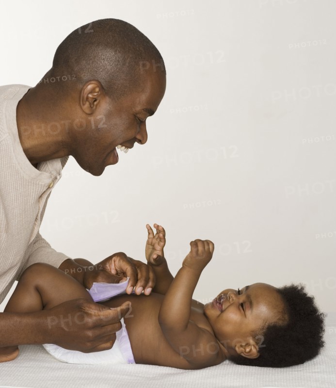 Father changing his baby daughter's diaper