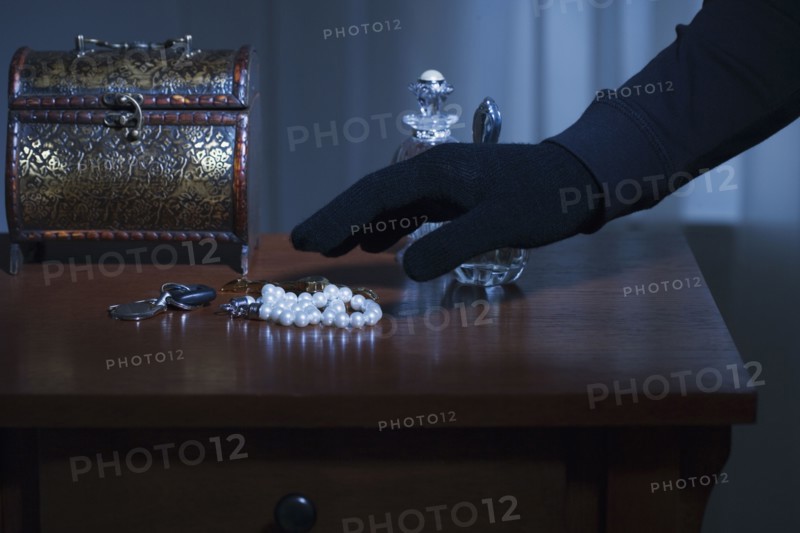 Thief reaching for a string of pearls