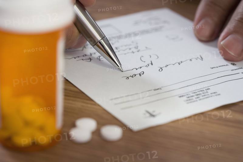 Close up of man filling out prescription