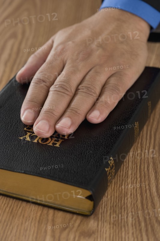 Close up of male hand on bible