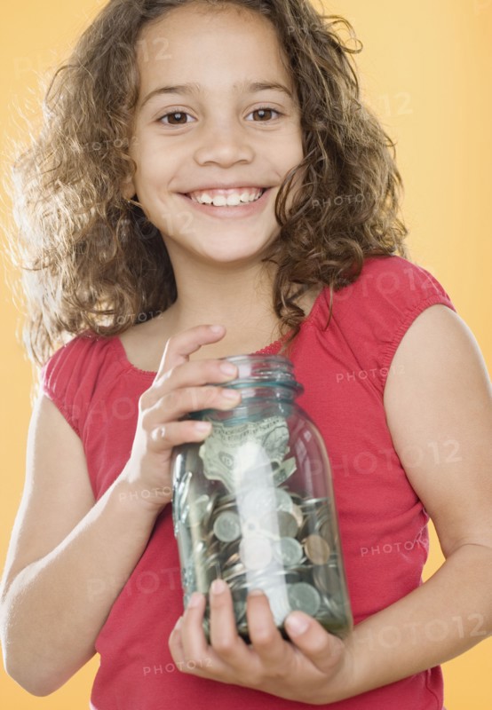 Young girl holding jar full of money