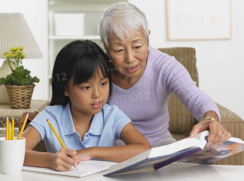 Asian grandmother and granddaughter doing homework