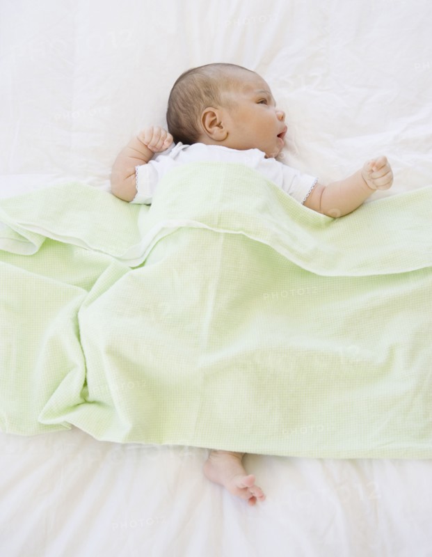 High angle view of newborn baby under blanket