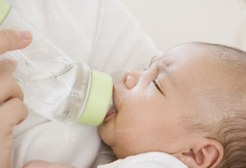 Close up of newborn baby drinking from bottle