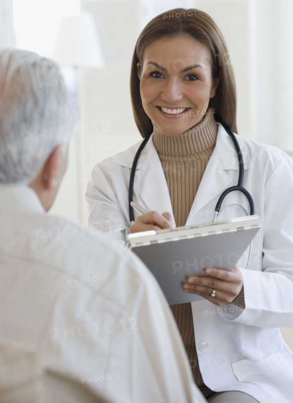 Portrait of Hispanic female doctor writing on chart