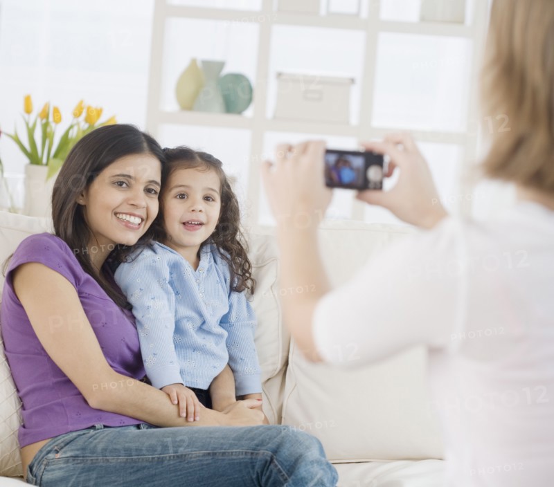 Hispanic mother and daughter having photograph taken