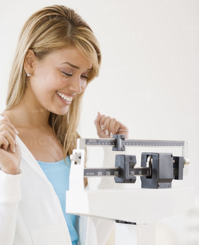 Hispanic woman weighing self