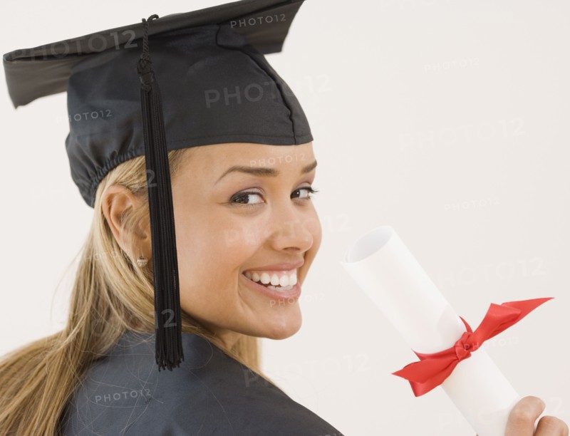 Young Hispanic woman wearing graduation cap and gown